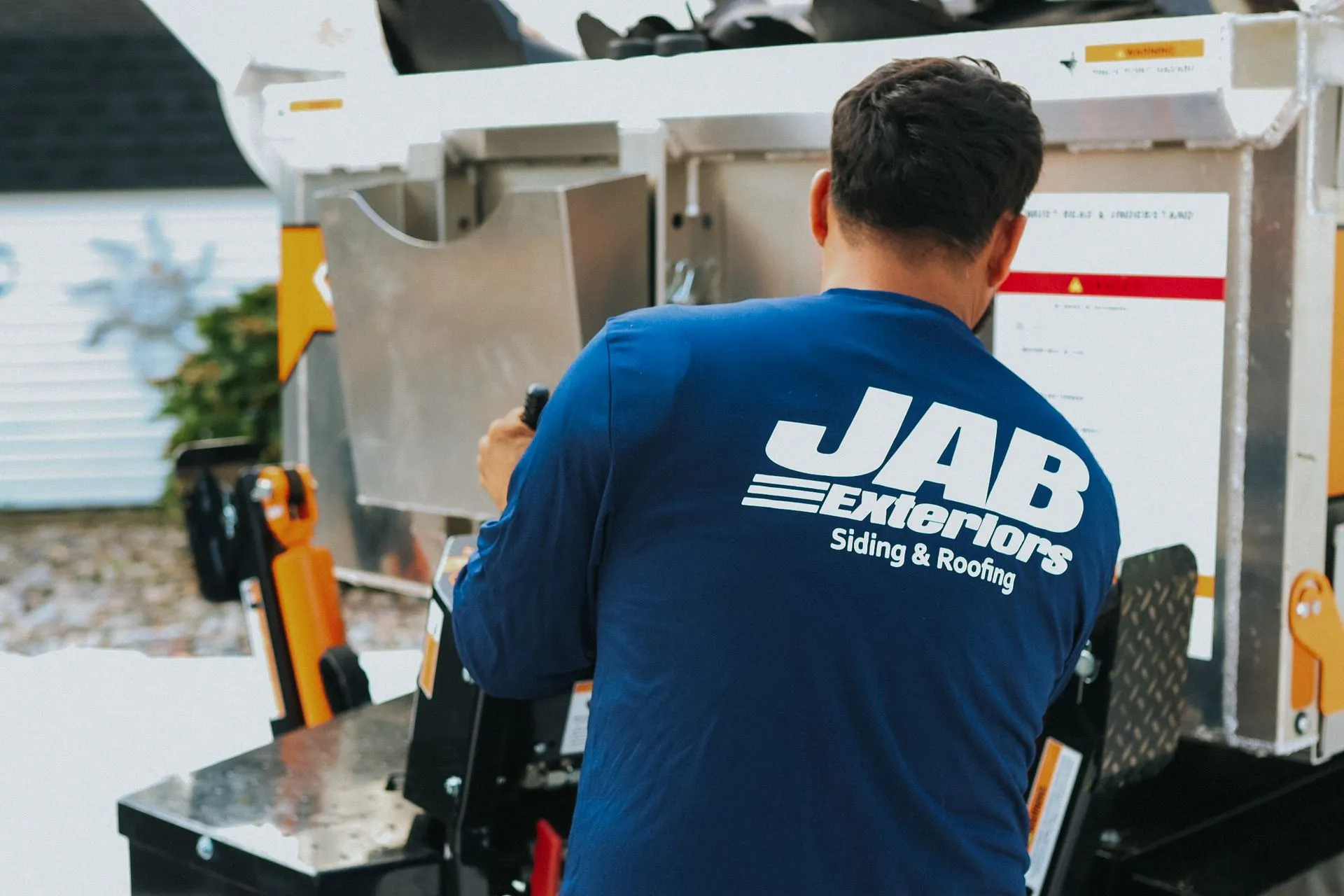 JAB Exteriors crew member operating gutter fabrication equipment