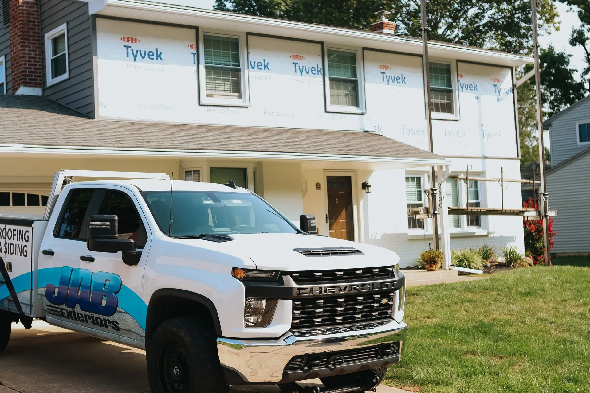 JAB Exteriors truck parked in front of a home being sided
